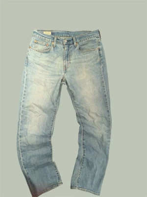 Levi's 501 ljusblå raka jeans - Klassiska ljusblå Levi's 501 jeans med rak passform och fyra fickor. Jeansen har en tidlös look med knappgylf och är tillverkade i slitstark bomullsdenim. Perfekta för dig som gillar vintage vibe och enkel stil.                                          INGET fel med dem. Passar mig som är 175