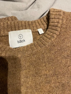  stickad tröja från Bläck - Mysig brun stickad tröja från Bläck med rund halsringning och ribbade muddar vid ärmslut och nederkant. Perfekt för lager-på-lager och enkel att matcha med jeans eller kjol. Klassisk och stilren design som funkar året runt. Storlek S men passar XS lika bra