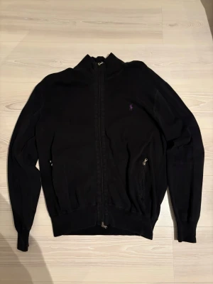 Svart zip från Ralph Lauren - Säljer en svart zip-kofta från Ralph Lauren. Den är i fint skick utan hål eller större defekter. Köpt begagnad här på Plick men säljs vidare då den tyvärr var för stor för mig. Hör gärna av dig vid frågor😄