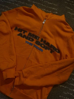HMHAS merch - Säljer en orange merch hoodie från Hit Me Hard And Soft The Tour av Billie Eilish. 