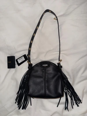 Maje väska  - Superfin väska från Maje i modellen”Miss M micro”. Svart. Helt oanvänd med prislapp kvar. Säljes då jag dessvärre inte kommer att ha användning för den. Dustbag medföljer. Djur- och rökfritt hem. Pris kan diskuteras🥰