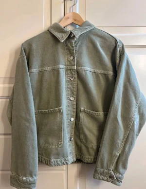 Grön jeansjacka med stora fickor - Snygg grön jeansjacka med klassisk krage och stora fickor framtill. Helt oanvänd.  Lånade bilder men min är exakt lika dan. Fraktar enbart via PostNord!!!! 