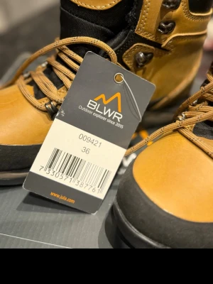 BLWR kängor i skinn, storlek 36 - Säljer ett par BLWR kängor i beige och svart skinn med grov mönstrad sula och snörning. Perfekta för utomhusäventyr, med metallhakar och robust design. Fodret är svart och skon har detaljer i syntetmaterial för extra slitstyrka. Helt nya med tags och allt är kvar! Hör av dig vid frågor😁 pris kan diskuteras🤩