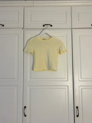 Ljusgul croppad t-shirt💖 - Säljer en ljusgul croppad t-shirt i mjuk bomull. T-shirten har korta ärmar och rund halsringning, perfekt för en chill och enkel stil. Passar dig som gillar basic men ändå vill sticka ut med en fräsch färg.