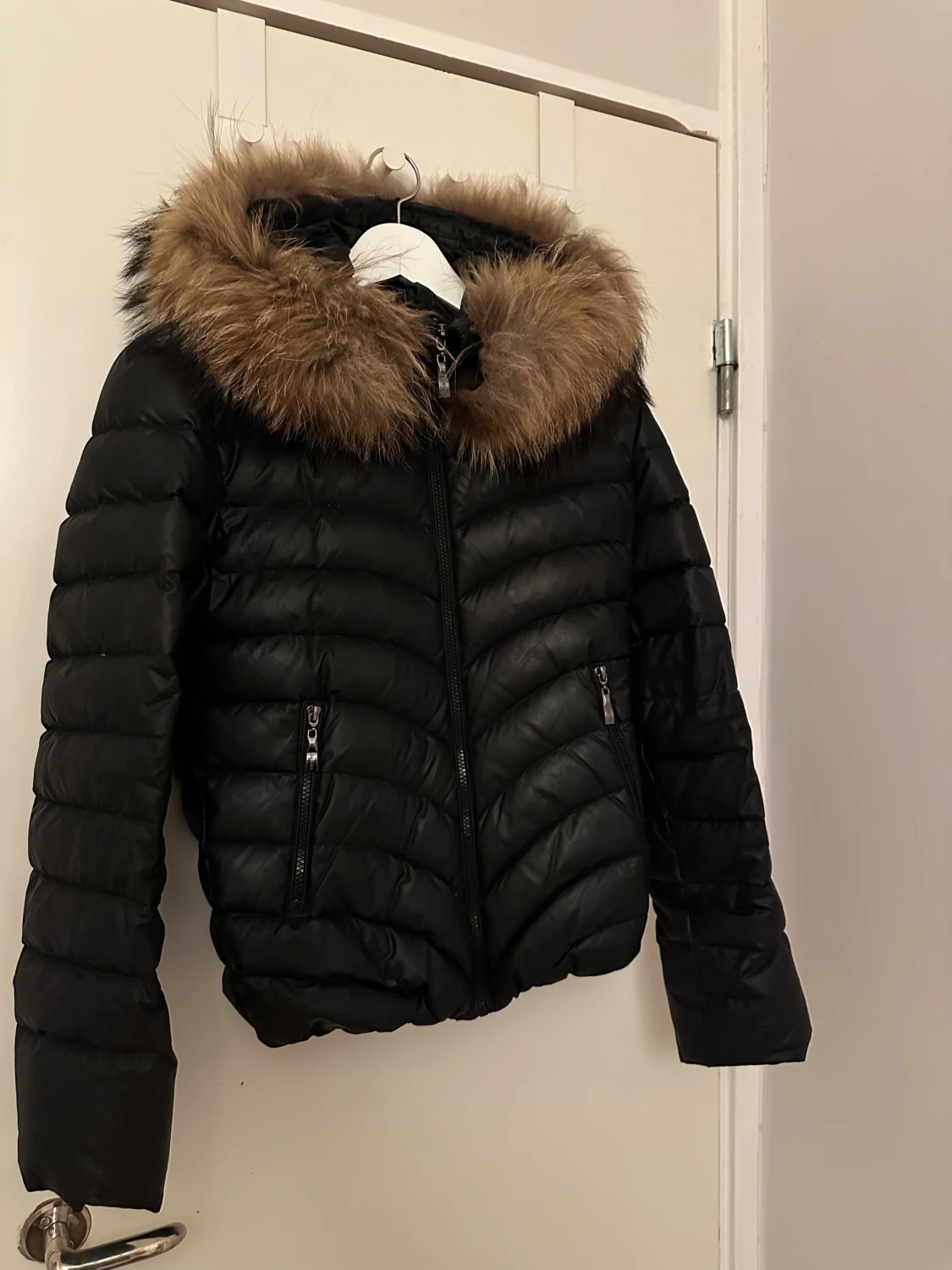 Svart pufferjacka med pälsluva