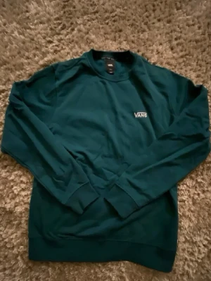 Mörkgrön sweatshirt från Vans i storlek S - En grön kofta från Vans i storlek S, tröjan är helt oanvänd och i ett gott skick. Har du några frågor så skriv gärna.