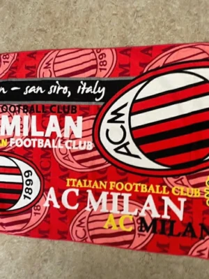 AC Milan fotbollsskor röd/svart - Säljer ett par fotbollsskor med AC Milan-tema i rött och svart med vita detaljer. Skorna har klubbens logga och årtal tryckt på sidan, samt mönster med ränder och klubbens emblem. Perfekt för dig som älskar italiensk fotboll och vill sticka ut på planen.