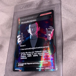 Giovanni's Scheme - Cool och glittrig Pokémon-tränarkort: Giovanni's Scheme! Perfekt för samlare och spelare som vill boosta sitt deck. Kortet är i skyddsfodral och har snygg design med unika effekter för ditt spel. Ett måste för alla Pokémon-fans!