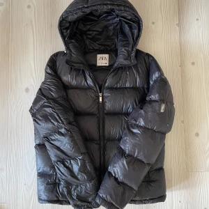 Svart pufferjacka från Zara - Säljer en populär och eftertraktad pufferjacka från Zara i storlek S. Den är väldigt identisk ’’Moncer Maya’’ och Polo Ralph lauren ’’The Gorham Glossed Jacket’’ Materialet är glansigt och syntetiskt, perfekt för kalla dagar. Nypris på denna är 1399:- Mitt pris är 699:- jackan är i bra skick, finns endast en liten skada på vänsterarm som är lätt att fixa bara att sy ihop eller använda sig av någon lapp/klister. Sitter endast tejp över för tillfället. Hör av dig vid frågor, ej hugget i sten. 