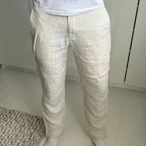 Beiga linnebyxor - Snygga och luftiga linnebyxor i beige med raka ben från Mango. Perfekta för en chill och stilren look. Modellen är 190cm, 78kg. Storlek 40 (EU). Skriv om ni har några funderingar:)