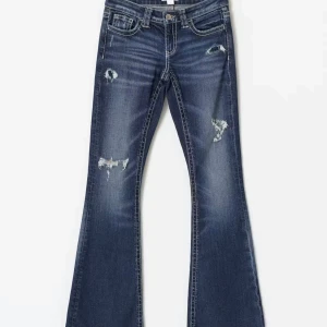 Blå bootcut jeans med slitningar - Snygga blå jeans med bootcut-modell och slitna detaljer på låren och knäna. Jeansen har klassisk femficksdesign, låg midja och är tillverkade i denim med en cool tvättad look. Perfekta för en avslappnad och trendig stil.