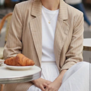 Beige randig kavaj från PLT - Snygg beige kavaj med smala vita ränder från PrettyLittleThing. Klassisk modell, oversize passform, lätt axelvaddering.