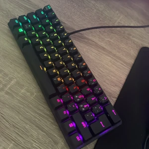 Razer Huntsman Mini - Razer Huntsman Mini 60% optiskt gamingtangentbord med RGB-belysning. Kompakt design, Razer optiska switchar och dubbelsprutade PBT-tangenter. USB-C kabel medföljer. Tangentbordet ser ut att vara i mycket gott skick utan synligt slitage.