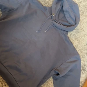 Mörkblå hoodie från 157, storlek S - Mysig mörkblå hoodie från 157 i storlek S. Tröjan har huva med snörning och långa ärmar med breda muddar. Perfekt för chill dagar och enkel att matcha med jeans eller mjukisbyxor.