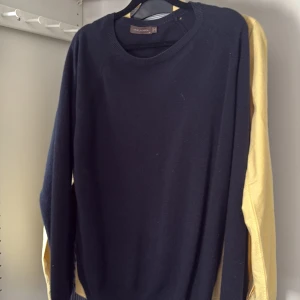 Mörkblå kashmirtröja Oscar Jacobson - Mjuk och stilren mörkblå tröja från Oscar Jacobson i kashmir. Klassisk rund halsringning och långa ärmar, perfekt för lager-på-lager under kyliga dagar. Enkel design som funkar till allt och ger en clean look.