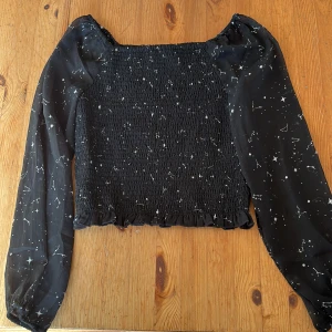 Svart topp med stjärnmönster KappAhl - Supersöt svart topp från KappAhl med vita stjärnor och konstellationer.