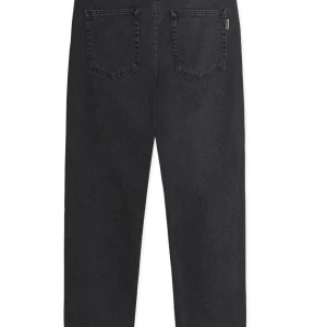 Svarta jeans från Woodbird, straight fit, helt oanvända  - Säljer ett par svarta jeans från Woodbird med klassisk femficksdesign och raka ben. Jeansen har hög midja och är tillverkade i robust bomullsdenim. Snyggt tvättad svart färg med diskret logga vid bakfickan. Perfekta för en clean och avslappnad look. Original priset på dessa är 1100 kr men säljer för 350 kr, storleken är 29/32