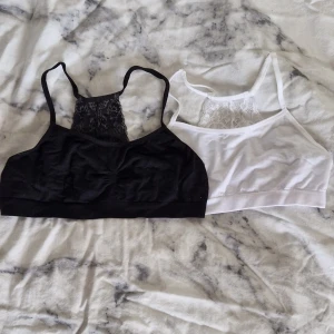 2 spetsdetaljerade linne-toppar svart/vit - Två linne-toppar i svart och vitt från Lindex och jag tror kapphal, båda med bred spetsdetalj baktill och smala axelband. Mjukt bomullsmaterial som är stretchigt och bekvämt. Perfekta att bära under tröjor. Storleken på den vita är 170 (14+) och den svarta står det ingen storleken på men är ungefär lika storlek🩷