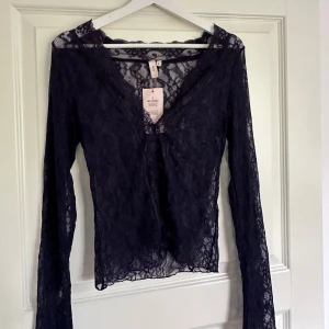 Mörkblå spetstopp från Nelly - Säljer denna populära toppen från Nelly! Mörkblå med spets. Aldrig använd, prislapp kvar