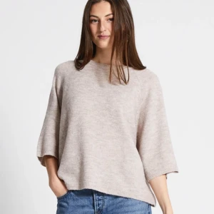 Beige stickad tröja från 157 - Beige stickad tröja från 157 i oversized modell med trekvartsärm och rund hals. 