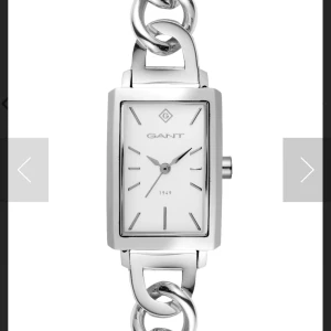 Gant Utica rektangulär klocka i silver - Snygg Gant Utica klocka med rektangulärt ur och länkarmband i blankt rostfritt stål. Urtavlan är vit med minimalistiska silverfärgade markeringar och Gant-logga. Länken har stora kedjelänkar som ger en cool och modern vibe. Perfekt accessoar för dig som gillar stilrena detaljer.