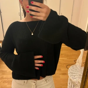 Svart stickad tröja från NA-KD - Svart stickad tröja från NA-KD med breda, långa ärmar och avslappnad passform. Tröjan är ribbstickad och har en croppad modell 💖💖