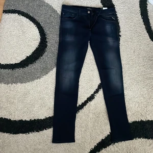 Replay Jondrill jeans mörkblå W31 L30 - Snygga mörkblå Replay Jondrill jeans med smal passform. Jeansen har diskreta slitningar framtill, dragkedjegylf och tydliga Replay-detaljer på fickorna. Perfekta för dig som gillar en modern och stilren look. Priset kan självklart sänkas vid snabb affär! Skriv vid funderingar. 