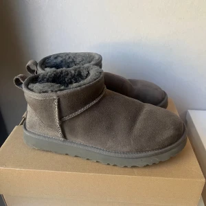 Uggs ultra mini grå - Gråa classic ultra mini uggs i storlek 39. De är i bra skick men finns tecken på användning