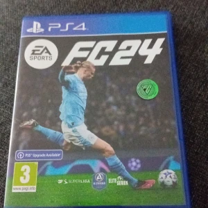 EA Sports FC24 PS4 spel - Säljer spelet EA Sports FC24 till PlayStation 4. Omslaget är blått med en fotbollsspelare i ljusblå matchställ på framsidan. Spelet har åldersmärkning 3 år och flera ligalogotyper syns på framsidan. Perfekt för dig som gillar fotbollsspel!