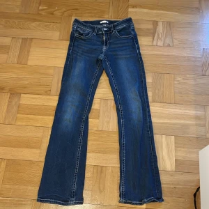 Mörkblå bootcut jeans med fickdetaljer - Snygga mörkblå jeans med bootcut passform och låg midja från Gina Tricot. Ny pris 400 men säljer för 100 då de är väl använda. Säljer för att de har blivit för korta för mig.