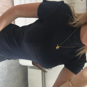 Svart polotopp från Bik Bok i ullmix - Svart polotopp från Bik Bok i mjuk ullblandning. T-shirttyp med korta ärmar och tight passform som sitter snyggt mot kroppen. Enkel och stilren design utan mönster eller detaljer, perfekt att styla med smycken eller lager på lager.