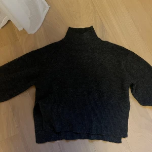 Mörkgrå stickad tröja med krage från Gina - Superfin mörkgrå stickad tröja med krage från Gina Tricot i storlek XS. Tröjan har ribbat krage och ärmslut, slits och har vida armar. 🤎🍂