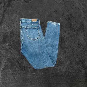 Blå jeans från Polo Ralph Lauren - Snygga blå jeans från Polo Ralph Lauren med klassisk femficksdesign och raka ben. Jeansen har en ljus tvätt och subtila slitningar för en avslappnad look. Tillverkade i bomull med bekväm passform och diskreta detaljer.