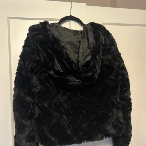 Svart pälsjacka med huva - Mysig svart pälsjacka med huva och lång ärm. Jackan har en fluffig känsla och är fodrad på insidan för extra komfort. ❣️ Pris går att diskutera❣️