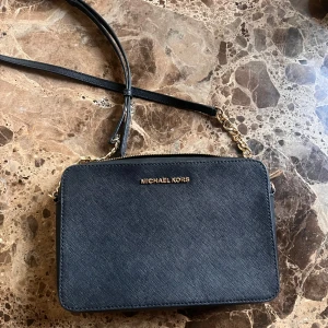 MICHAEL KORS jet set travel CROSSBODY - En knappt använd MICHAEL KORS axelbands väska i extremt bra skick, detaljer finns på bild som visar på äkthet! Svart med gulddetaljer, nypris: 2195. Pris kan diskuteras vid snabb affär🖤