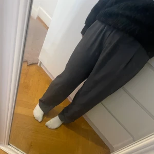 Grå kostymbyxor med hög midja - Säljer ett par grå kostymbyxor  med loose passform och hög midja. De har en enkel och stilren look, perfekta för dig som gillar bekväma och snygga plagg. Materialet känns mjukt och följsamt mot kroppen. Storlek 34 men passar mer som 32