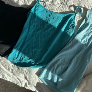 3 linnen i svart, turkos och ljusblått - Säljer tre linnen: ett svart med tunna axelband, ett turkost med smala axelband och ett ljusblått ribbat linne från Weekday. Perfekta för sommaren och lätta att matcha med jeans eller kjol. Alla är ärmlösa och i mjukt material. Jag säljer alla för endast 150kr!!! 