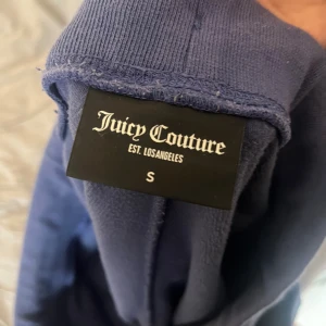 Mörkblå mjukisbyxor Juicy Couture S - Mörkblå mjukisbyxor från Juicy Couture i storlek S. Byxorna har snörning i midjan med guldfärgade detaljer, två fickor med silverfärgade  knappar och broderad JC-logga. Materialet är mjukt och skönt. Använda ett fåtal gånger då de var lite stora💕