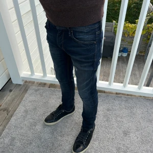 Mörkblåa jeans från Jack and Jones W29/L30 - SUPERFETA!! Jack and Jones jeans med häftiga revor i färgen mörkblå. Modellen på jeansen är skinny/liam. Storlek 29/30. Nyskick 10/10! 😀