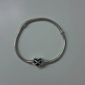 Silvrigt pandora armband - Ett silvrigt pandora armband som är 17 cm långt. Vilket motsvarar en handled som har 15 cm omkrets. (Se storlekar vid sista bilden). Armbandet är ungefär 3 år gammalt men knappt andvänt. Säljs på grund av att det är lite litet samt är knäppet lite trögt. Nyköpt armband säljs för 899kr.                   