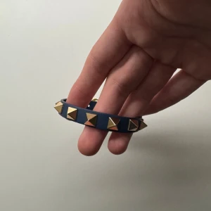 Valentino armband  - Coolt mörkblå valentino armband med pyramidformade guldfärgade nitar runt om. Funkar för alla outfits som en snygg detalj. Kan diskutera pris 