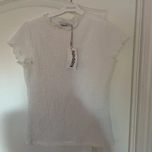 Tröja - Vit tunn tröja från Kappahl. Materialet har textur och är väldigt skönt. Det är en liten krage uppe vid halsen. Tröjan är lite genomskinlig beroende på vad man har under. 