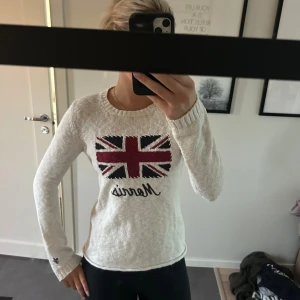 Vit stickad tröja Morris Lady - Vit stickad tröja från Morris Lady med Union Jack-flagga och broderad logga framtill. Rund halsringning, ribbade muddar och långärmad modell. Bra skick och storlek S.