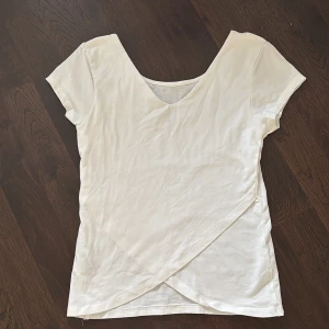 Vit omlottopp från Cubus - Säljer en vit omlottopp från Cubus i mjuk bomull med lite stretch. Toppen har korta ärmar, v-ringning och en snygg omlottdetalj framtill. Perfekt för dig som gillar enkel och stilren look.