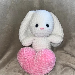 Virkad kanin med hjärta - Söt handgjord virkad kanin i mjuk, vit plysch med långa öron och ett rosa hjärta. Ca 22 cm hög