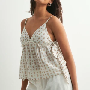 Vit topp från Nelly - Supersöt vit topp från Nelly med beiget mönster💝använd fåtal gånger, superbra skick💞