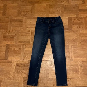 Mörkblå jeans från Ralph Lauren - Snygga mörkblå jeans från Ralph Lauren med klassisk femficksdesign och skinny passform. Jeansen har en smal siluett, orangea sömmar och är tillverkade i stretchigt denim med bomull, polyester och elastan för extra komfort.