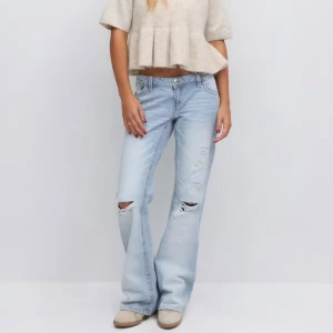 Ljusblå bootcut jeans med slitningar - Säljer ett par ljusblå jeans med bootcut/rak passform och snygga slitningar över knäna. Jeansen har klassisk femficksdesign, låg midja och är tillverkade i mjukt denim. Jag beställde de och de passade tyvärr inte och hann aldrig lämna tillbaka, har aldrig använts bara prövat💕💕 Tyvärr för stora för mig och råkade beställa en storlek för stor