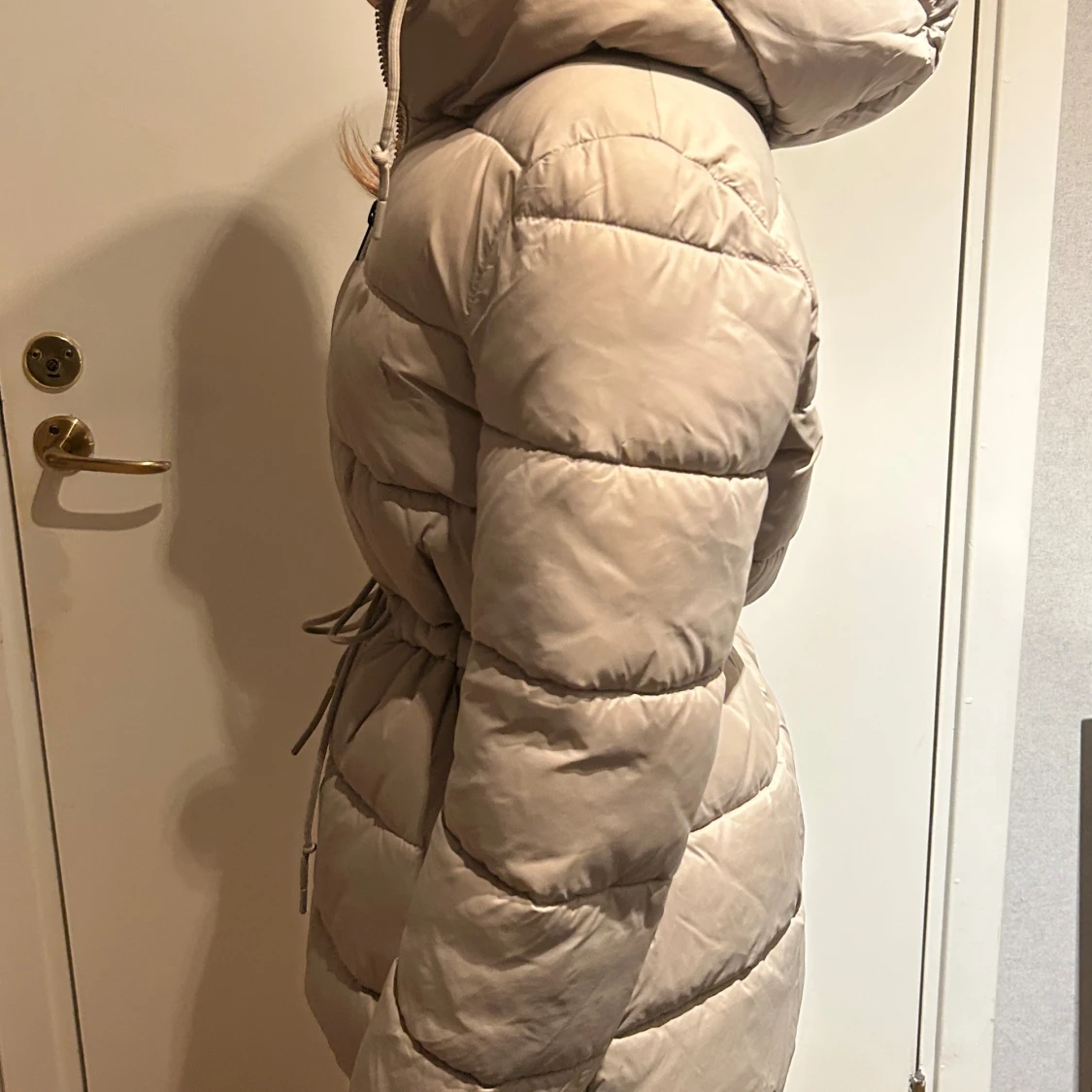 Beige pufferjacka med huva och snörning - 1