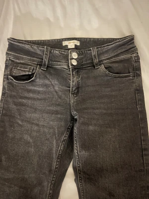 Svarta jeans från Gina Tricot, stl 158 - Snygga svarta jeans från Gina Tricot i storlek 158. Jeansen har dubbla knappar i midjan och klassiska fickor fram och bak.